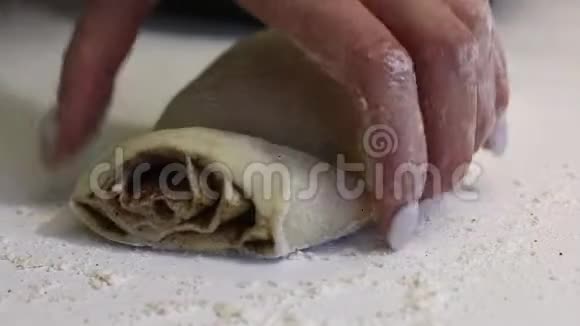 一个女人用擀面团切块来做朱砂把它们放在烤盘上视频的预览图