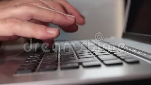 在笔记本电脑的键盘上写字时人的双手特写视频的预览图