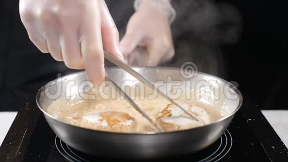 做海鲜健康的食物概念专业厨师在手套中烹饪葱用粗钳子把它们翻过来视频的预览图