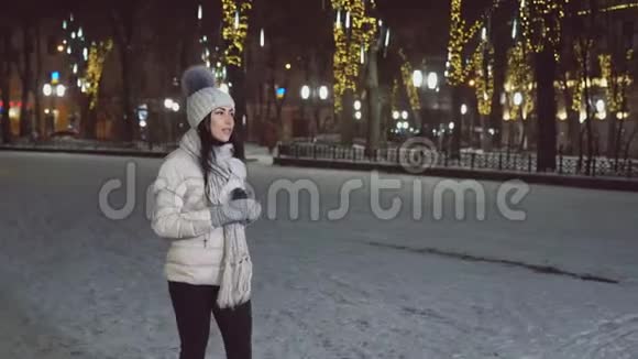 冬天穿衣服的女孩走路喝咖啡视频的预览图