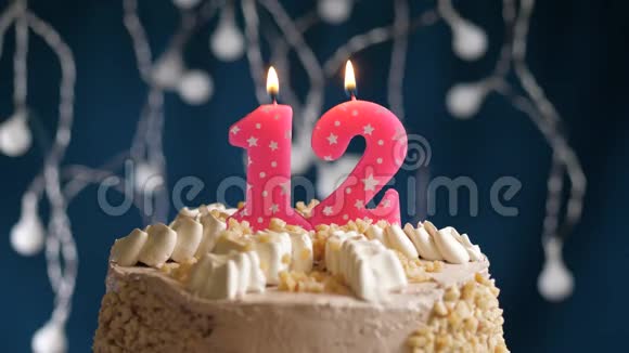 生日蛋糕蓝色背景上有12个数字的粉红色燃烧蜡烛蜡烛吹灭了慢速运动和特写镜头视频的预览图