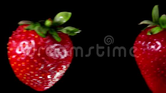 两个多汁的美味草莓碰撞在黑色的背景上视频的预览图