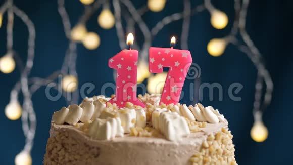 生日蛋糕蓝色背景上有17个数字的粉红色燃烧蜡烛蜡烛吹灭了慢速运动和特写镜头视频的预览图