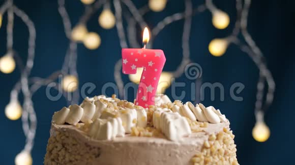 生日蛋糕蓝色背景上有7个数字的粉红色燃烧蜡烛蜡烛吹灭了慢速运动和特写镜头视频的预览图