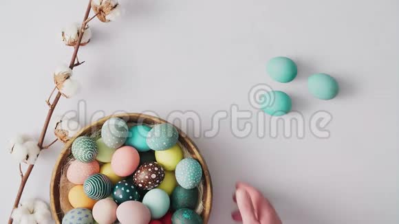 手拿起篮子与彩色复活节彩蛋在明亮的背景复活节节日装饰品复活节概念背景视频的预览图