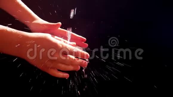 孩子们在一条小溪下的手太阳喷雾孩子洗了手视频的预览图
