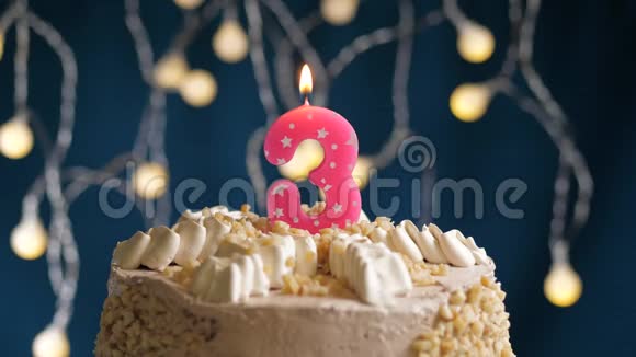 生日蛋糕蓝色背景上有3个数字的粉红色燃烧蜡烛蜡烛吹灭了慢速运动和特写镜头视频的预览图