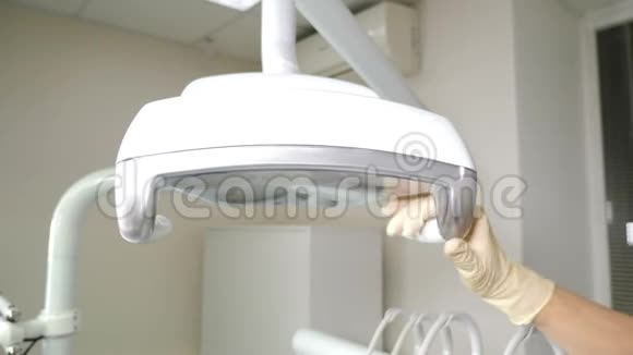 牙科开始治疗降低牙科灯和打开它专业牙医办公室特写镜头牙科视频的预览图