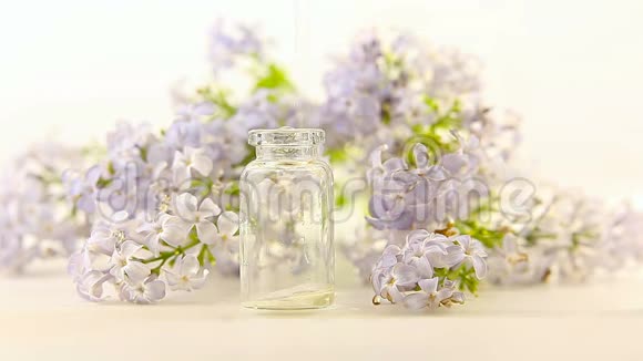 白色背景上的鲜花精华白色背景上的鲜花精华漂亮的玻璃罐中的盘根错节精油视频的预览图
