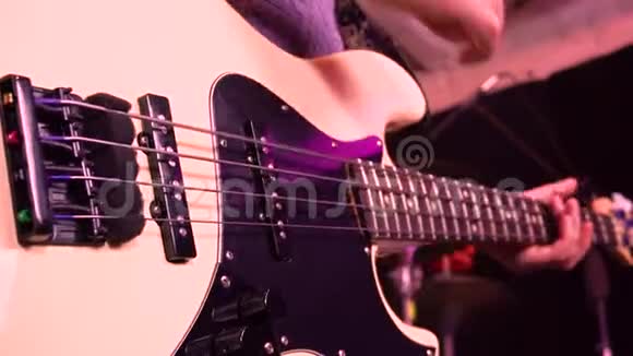 弹贝斯吉他在舞台灯光的光线下视频的预览图