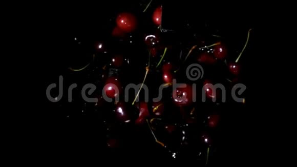 美味多汁的樱桃在黑色背景上溅起水花视频的预览图