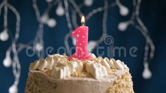 生日蛋糕蓝色背景上有1个数字粉红色燃烧蜡烛蜡烛吹灭了慢速运动和特写镜头视频的预览图