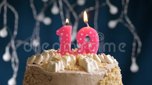 生日蛋糕蓝色背景上有19个数字的粉红色燃烧蜡烛蜡烛吹灭了慢速运动和特写镜头视频的预览图