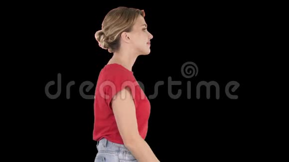 穿着牛仔裤和t恤走着的女人阿尔法频道视频的预览图