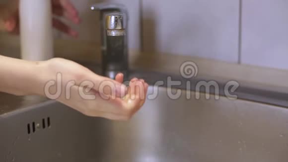 不知名人士在水龙头下洗手用白色液体肥皂消毒器中的肥皂试图洗掉微生物洗手视频的预览图