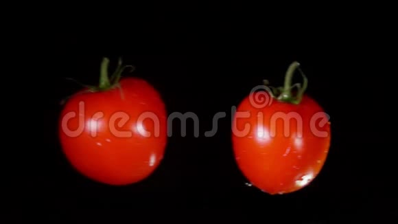 两个成熟的红西红柿正在碰撞不断上升的水滴和飞溅的水视频的预览图