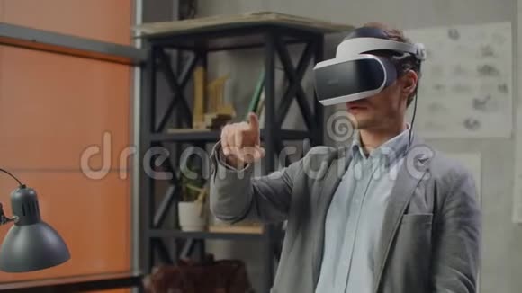 年轻的男工程师戴着虚拟现实头盔用手做动作模仿图形视频的预览图