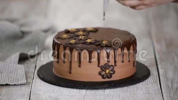 糖果制造者用融化的巧克力装饰美丽的奶油蛋糕视频的预览图
