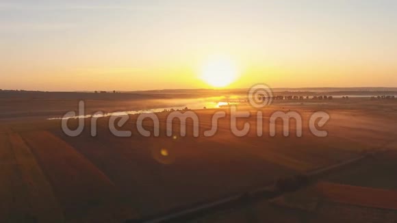 空中景观电影无人机镜头在日落时间在乌克兰的一条河的上空飞行在黄昏的薄雾中有田野视频的预览图