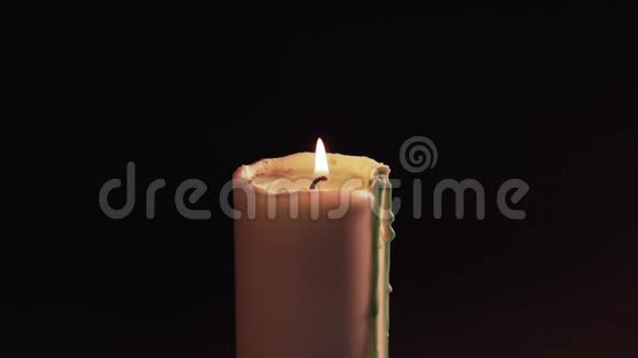 孤独的蜡烛在黑色的背景下燃烧分离火焰燃烧和绿蜡扩散视频的预览图