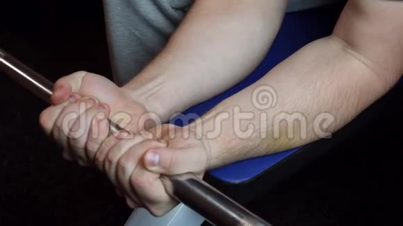 一个人坐在长凳上用杠铃在前臂做运动视频的预览图