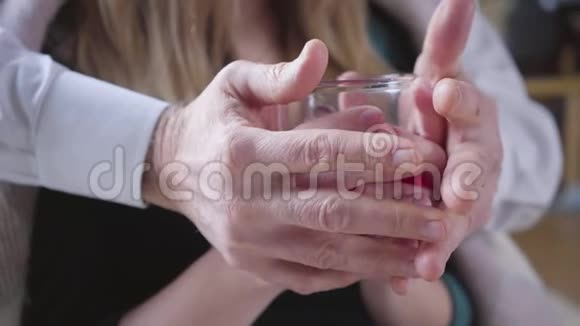 特写高雄白种人手抚着年轻的雌性手掌拿着茶杯年龄的夫妻团结视频的预览图