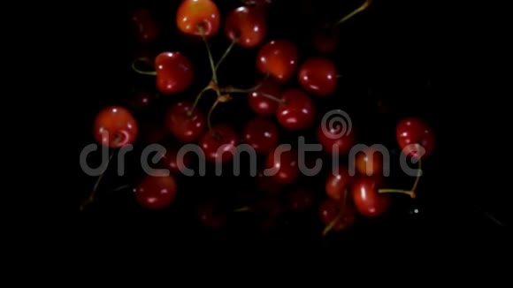 鲜辣的红樱桃在黑色背景上溅起水花视频的预览图