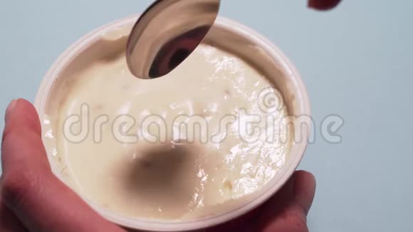 女人用勺子吃无麸质酸奶女人的手用勺子拿起一块干酪放在白色的地上视频的预览图