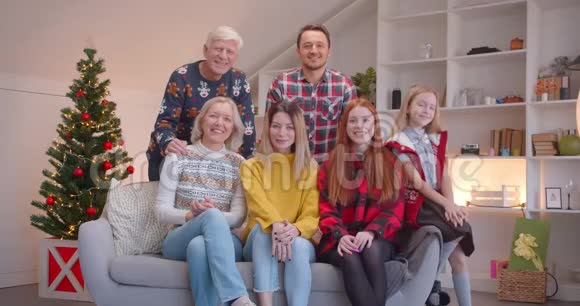 一家人坐在沙发上圣诞画像高兴地鼓掌视频的预览图