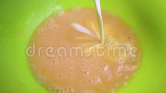 将白色牛奶倒入黄色混合物中用一种惊人的方式与打鸡蛋混合混合面团的原料Maki的过程视频的预览图