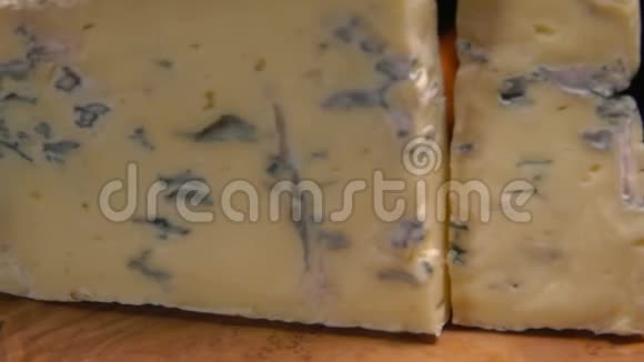 一块美味的蓝色罗克福特奶酪掉在木板上视频的预览图