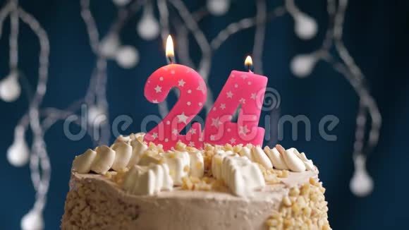 生日蛋糕24号粉红色燃烧蜡烛在蓝色背景蜡烛吹灭了慢速运动和特写镜头视频的预览图