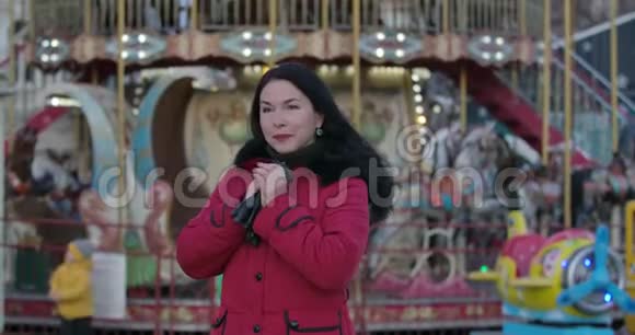 穿红色外套戴皮手套的中年白种人的肖像站在城市的迷人成年女士视频的预览图