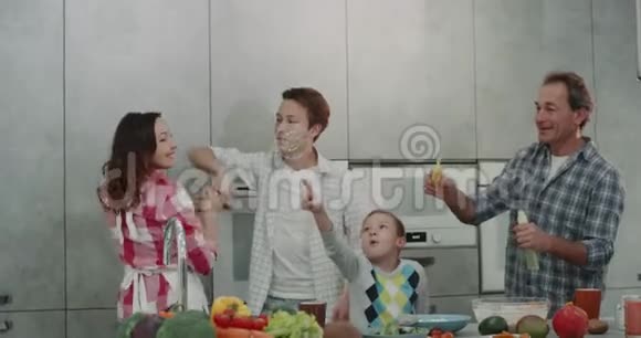 厨房里漂亮的一家人在跳舞和做泡泡的时候玩得很开心成年的父母和两个9岁的男孩视频的预览图