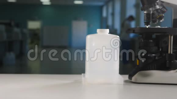 现代实验室理念戴黑手套的科学家把装有显微镜的白色塑料瓶视频的预览图