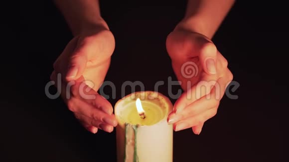 女人手上方燃烧的蜡烛特写魔火女巫预言在黑色背景上隔离静止视频的预览图
