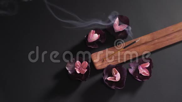 在木架上黑色背景上的芳香宗教棍子在水疗中心干燥芬芳的舒缓花概念视频的预览图