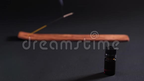 芳香油背景下的蒸香棒分离在黑色背景上治疗的概念视频的预览图