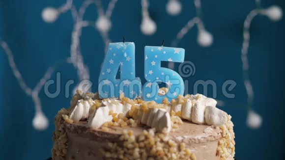 生日蛋糕蓝色背景上有45号蜡烛蜡烛吹灭了慢动作和特写视频的预览图