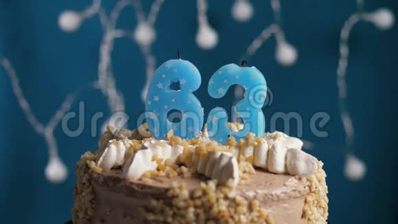 生日蛋糕上有63支蜡烛在蓝色的背景上蜡烛吹灭了慢动作和特写视频的预览图