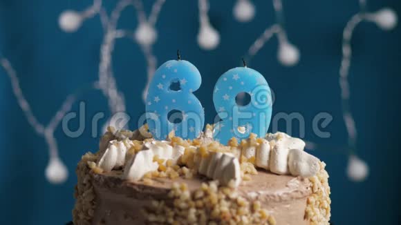 生日蛋糕蓝色背景上有69支蜡烛蜡烛吹灭了慢动作和特写视频的预览图