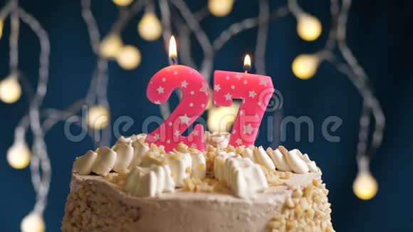 生日蛋糕蓝色背景上有27个数字的粉红色燃烧蜡烛蜡烛吹灭了慢速运动和特写镜头视频的预览图