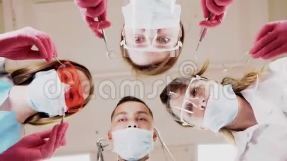 戴着牙科工具的医生在病人面前蒙面视频的预览图