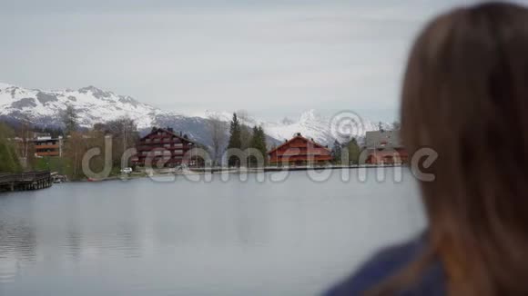 女人欣赏湖光山色在阳光明媚的春天放松后景重点过渡视频的预览图