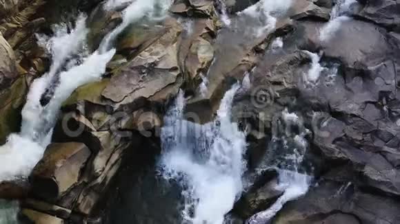 山河水面的鸟瞰图蓝色水的小水滴岩石之间流动的溪流的俯视图视频的预览图