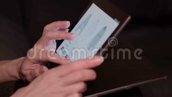 在家里用平板电脑上网订购衣服的女士的特写视频的预览图