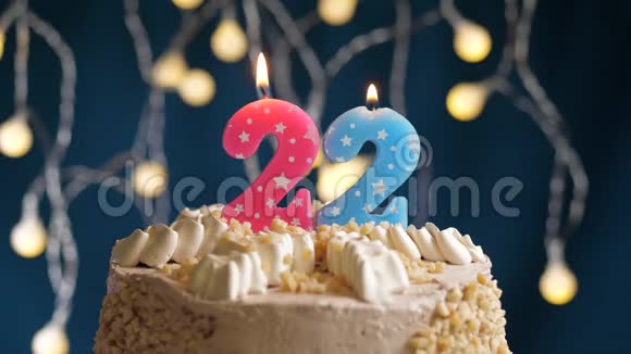 生日蛋糕蓝色背景上有22个数字的粉红色燃烧蜡烛蜡烛吹灭了慢速运动和特写镜头视频的预览图