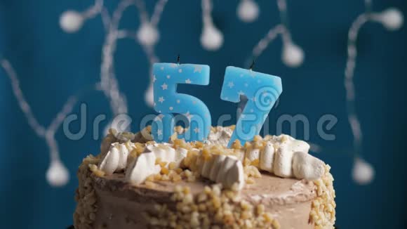 生日蛋糕57号蜡烛在蓝色的背景上蜡烛吹灭了慢动作和特写视频的预览图