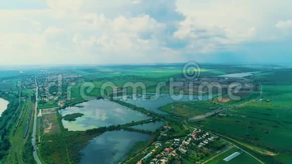 全景的绿色景观几个池塘和雾蒙蒙的山在地平线上视频的预览图