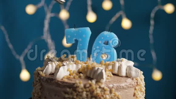 生日蛋糕76号蜡烛在蓝色的背景上蜡烛吹灭了慢动作和特写视频的预览图